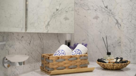 Beautiful bathroom decoration with a towel basket and a plate with cosmetics.